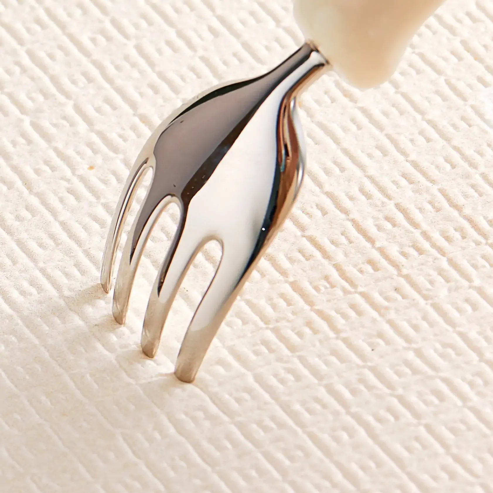 Metallic fork on a textured beige surface