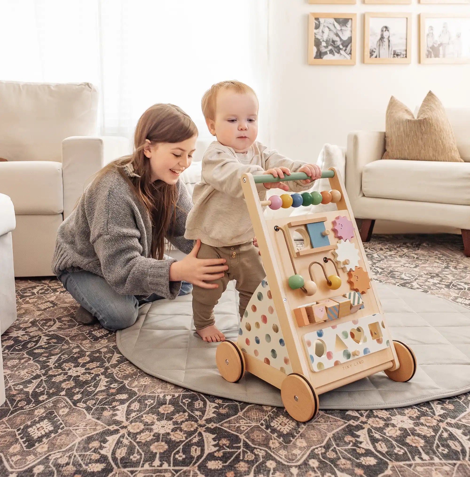 Woman and child playing with a wooden activity toy in a living room.