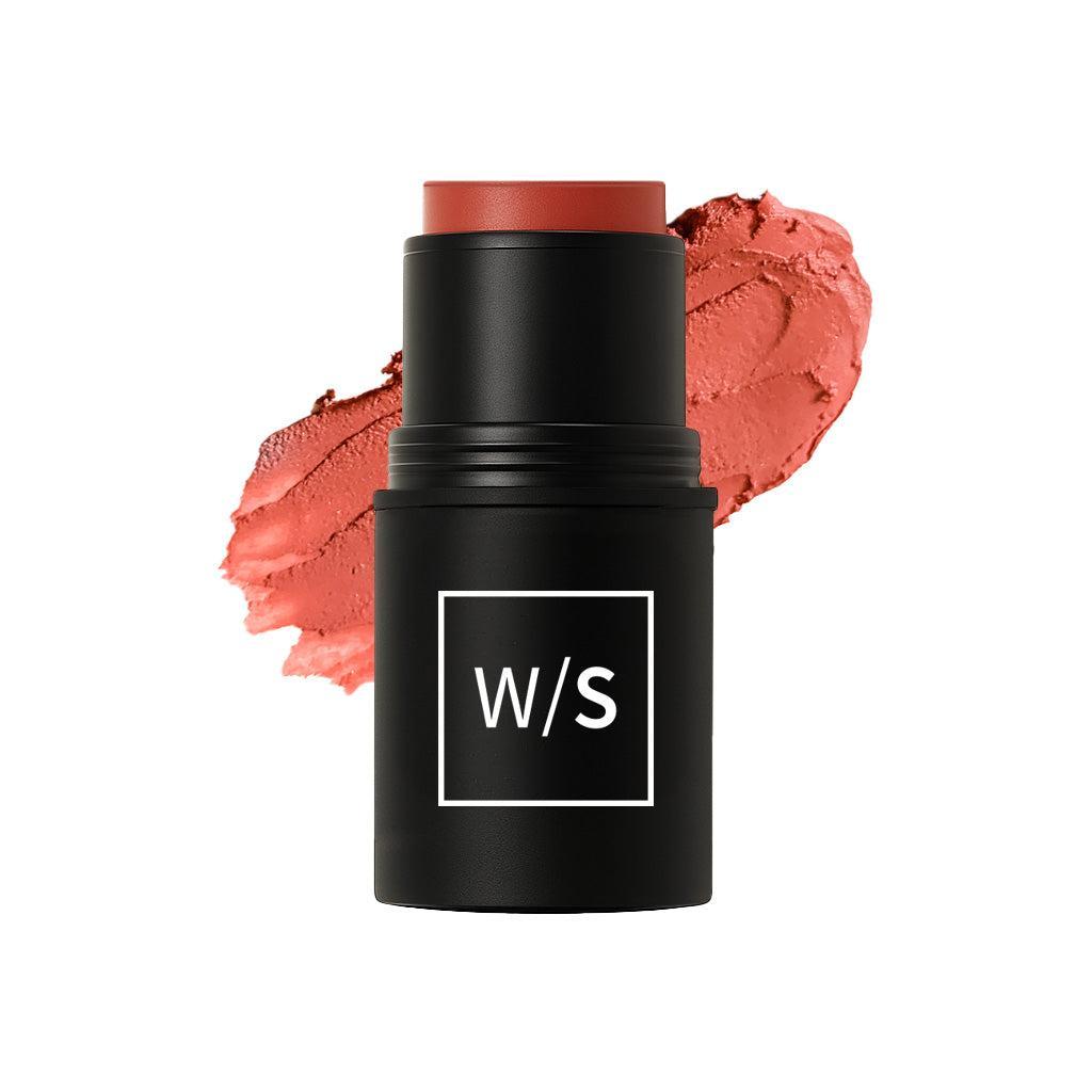 Black makeup stick with coral color swatch on a white background
