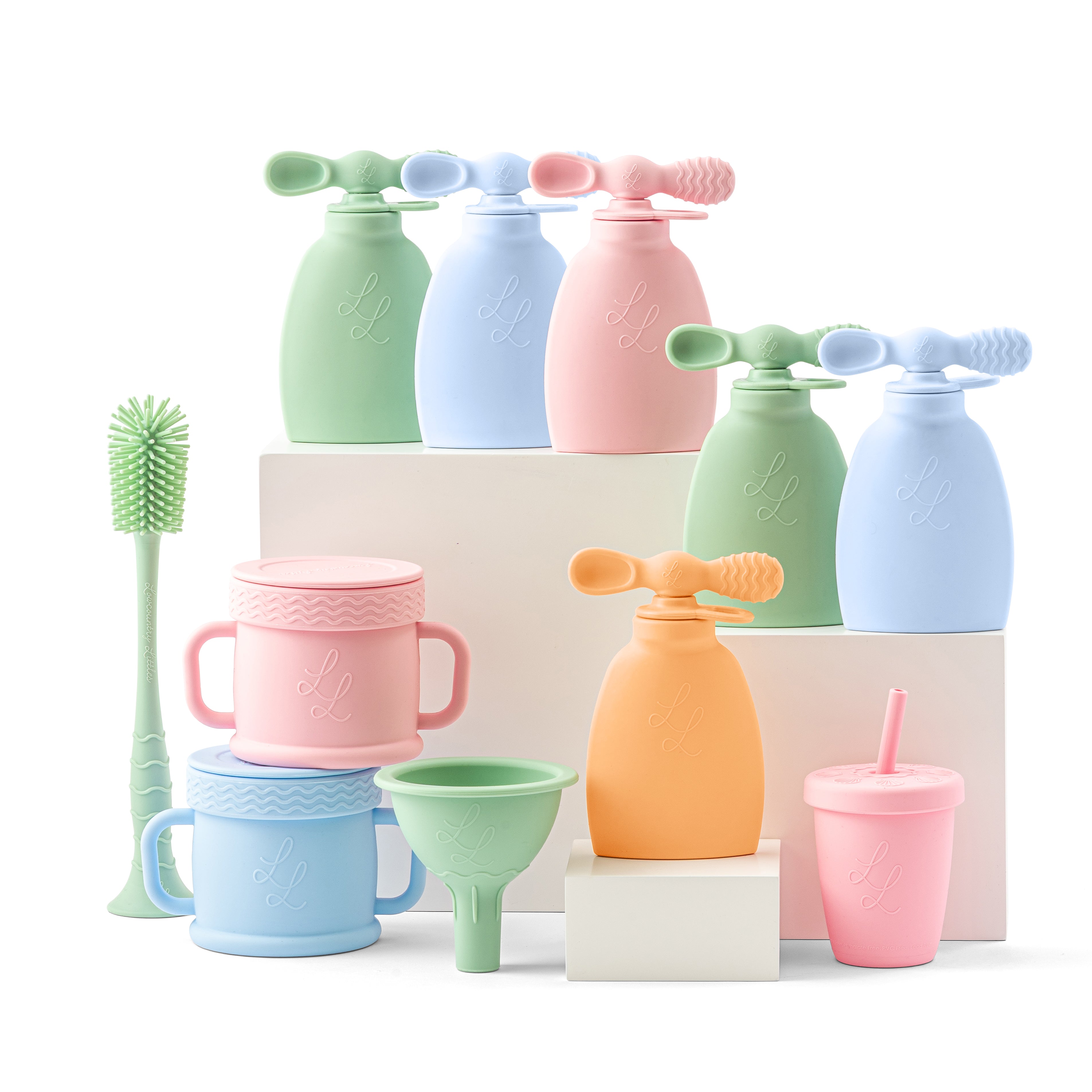 Set of colorful silicone kitchen tools including cups, funnels, and bottles on a white background