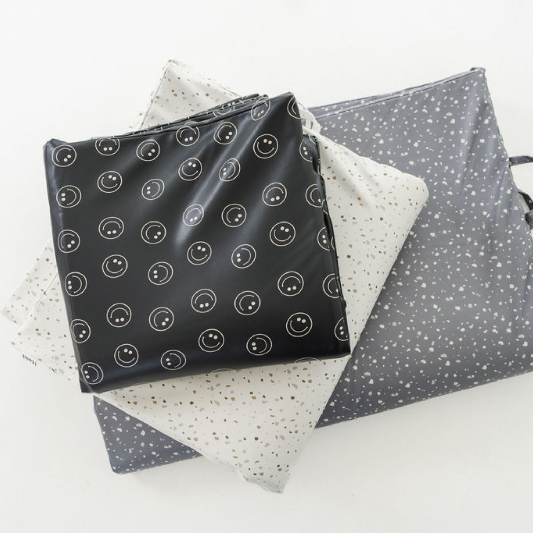 Set of patterned bags including black with white circle design, gray with white dot design, and white with gray dot design.
