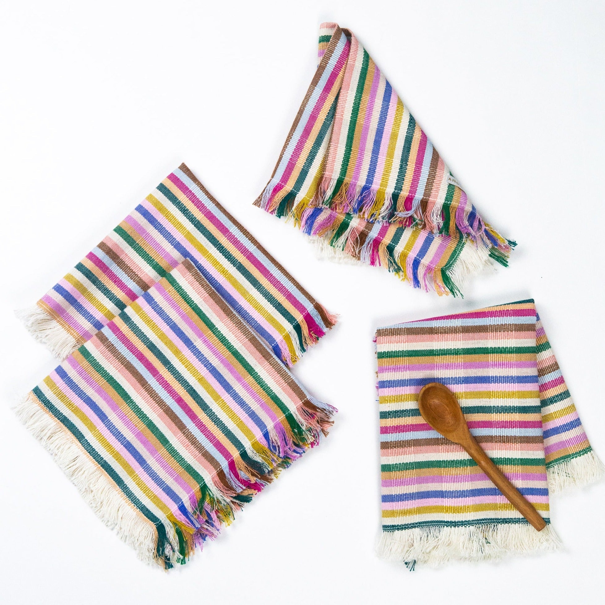 Set of colorful striped towels with fringes on a white background
