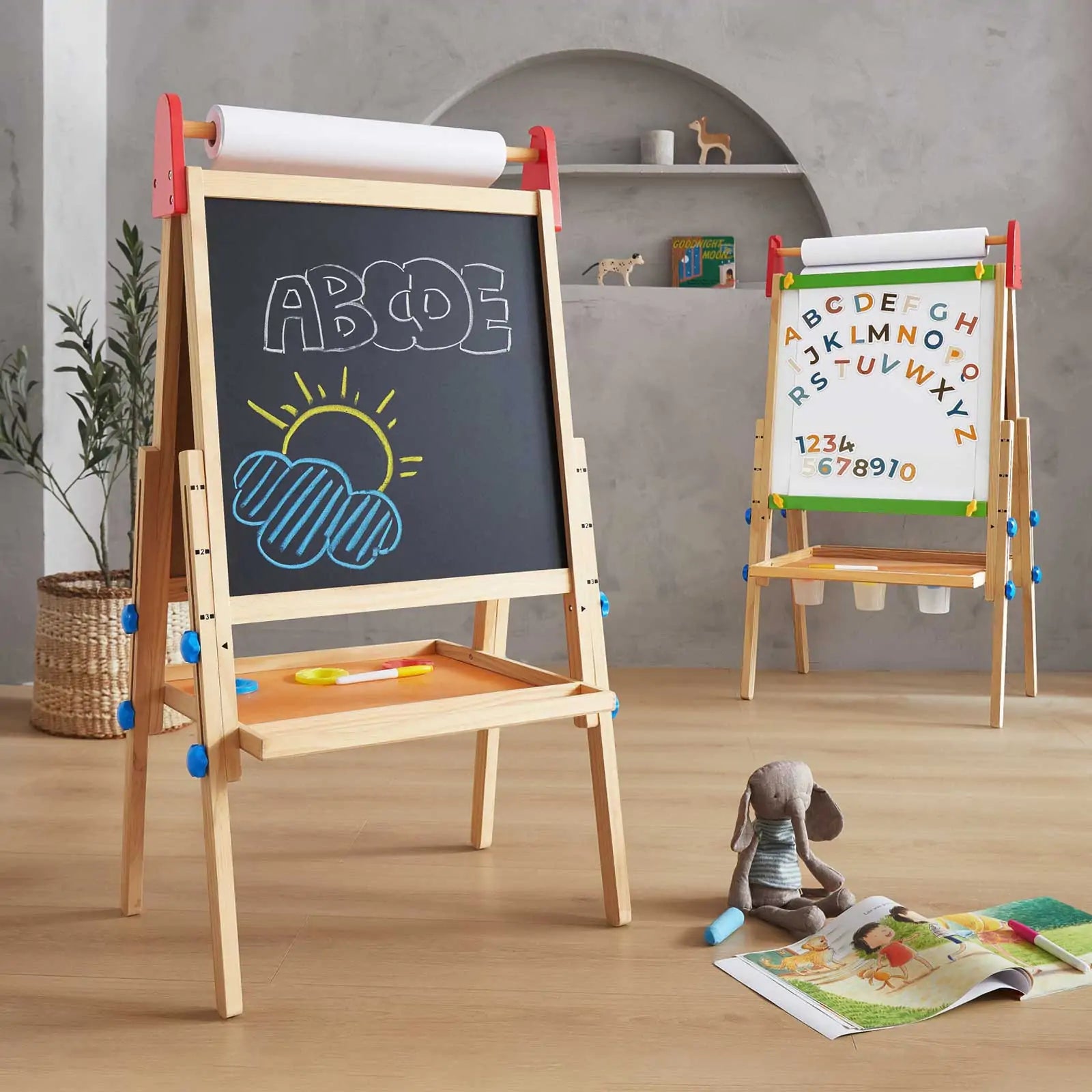 Children's wooden easel with chalkboard and whiteboard surfaces, featuring educational content, in a room setting.