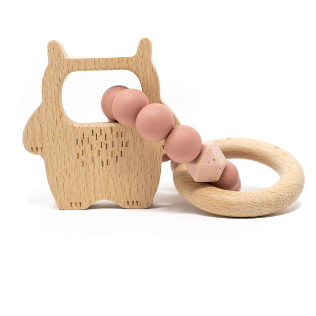 Wooden teething ring with pink silicone beads on a white background