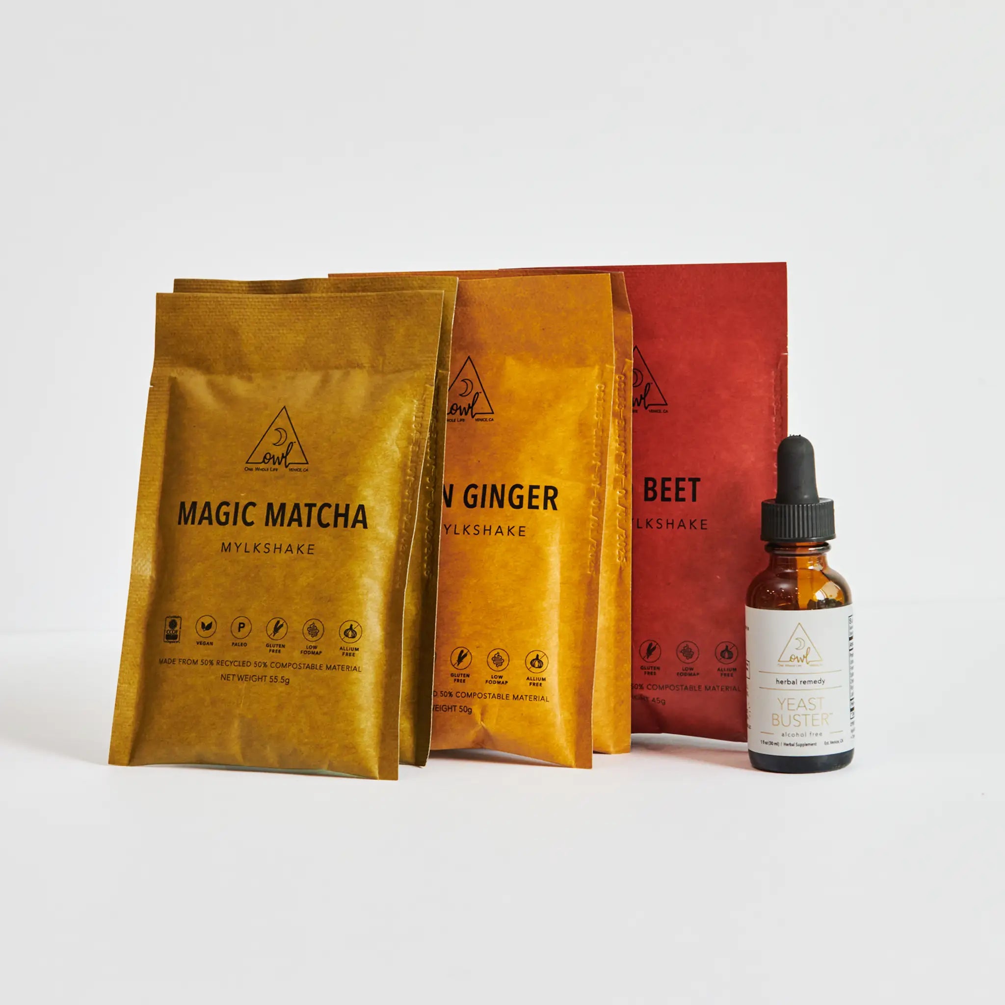 Three packages labeled 'Magic Matcha', 'Raw Ginger', and 'Beet' with a dropper bottle on a white background.