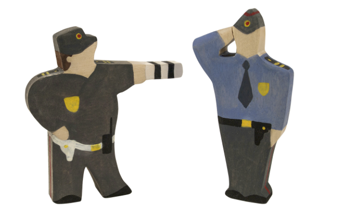Two wooden toy figures of police officers on a white background
