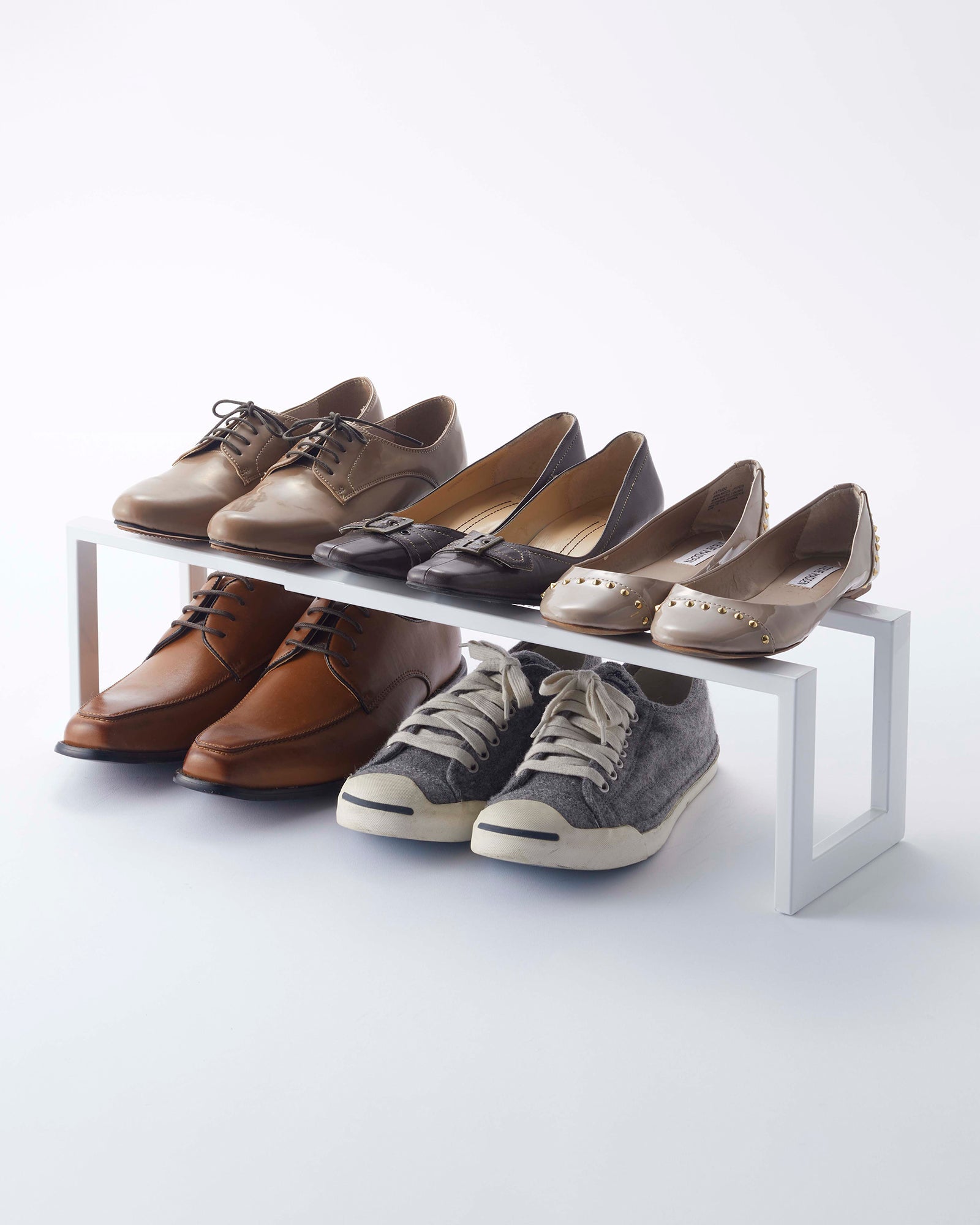 Set of shoes displayed on a white rack against a white background