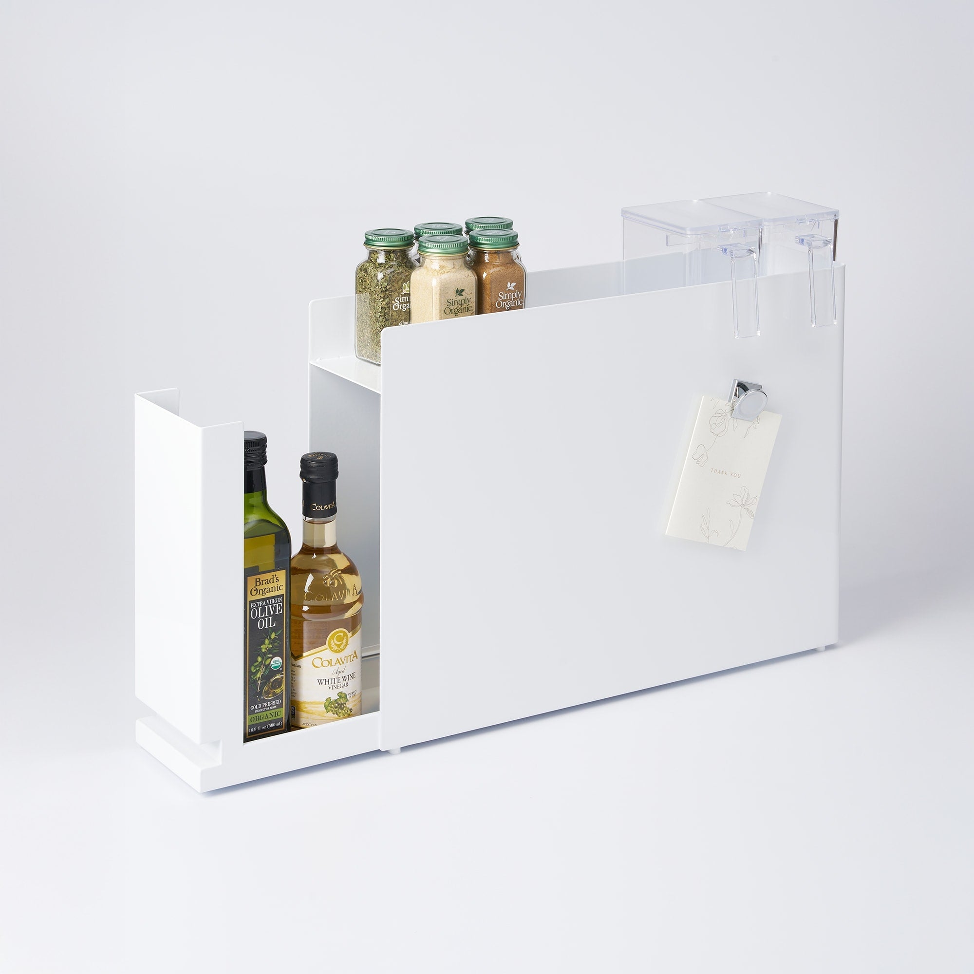 White gift box with olive oil bottles and a tag on a light gray background