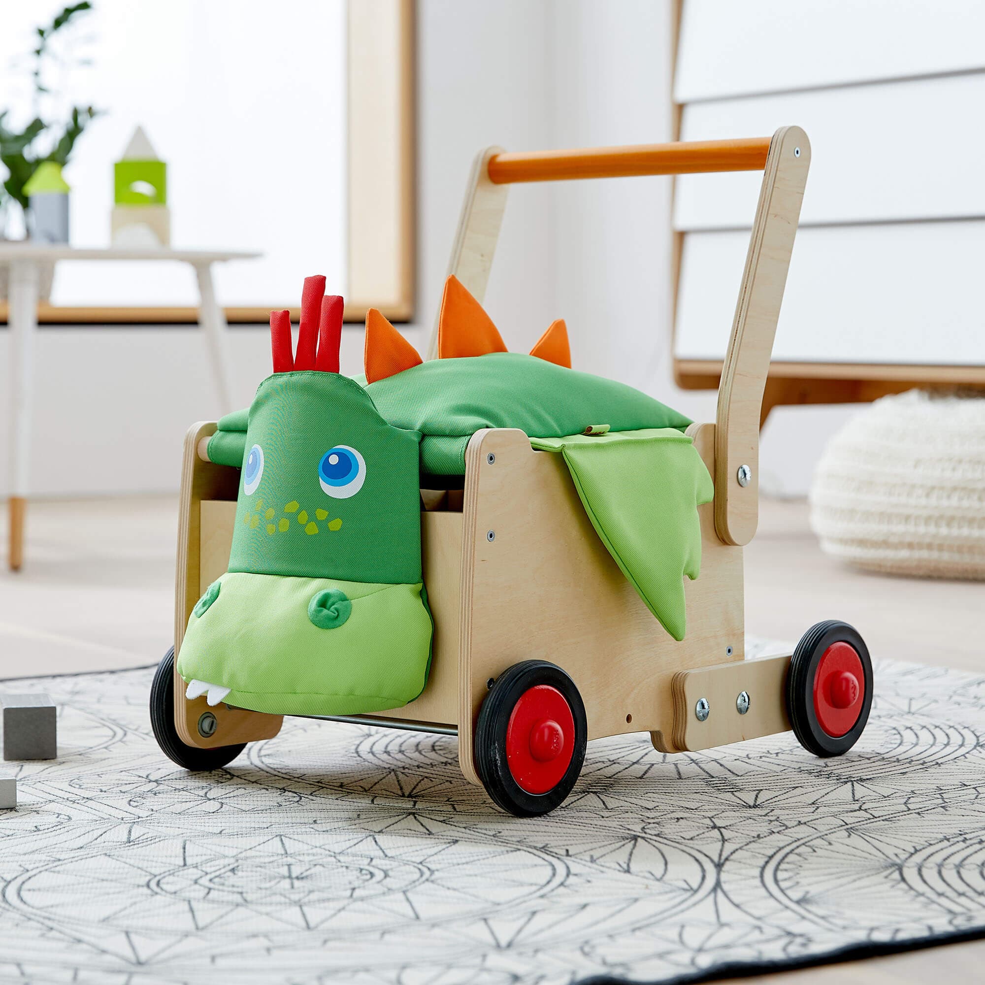 Children's toy cart with dinosaur design on a light-colored floor.