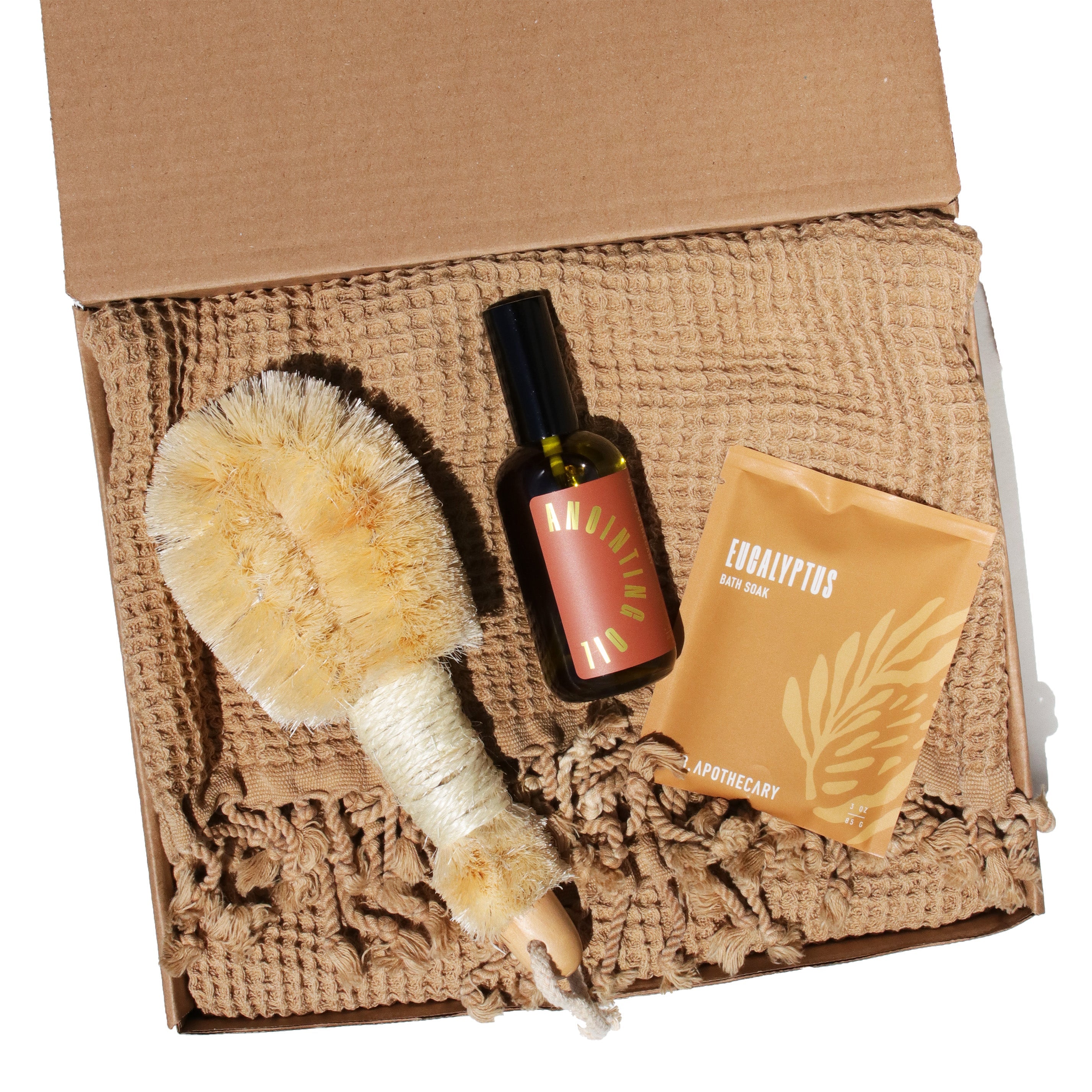 Body care set with brush, bottle, and pouch on a textured surface