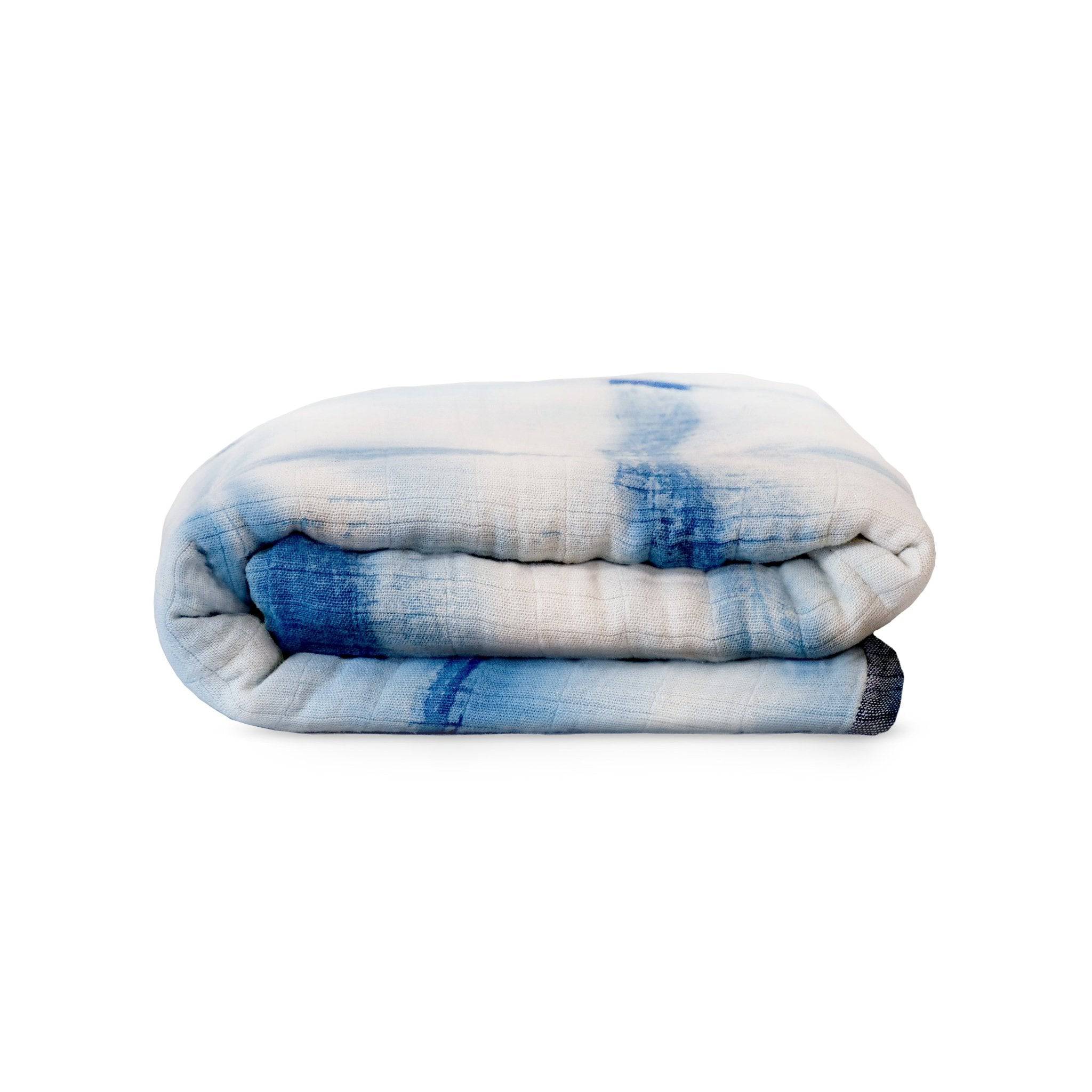 Folded blue and white striped blanket on a white background