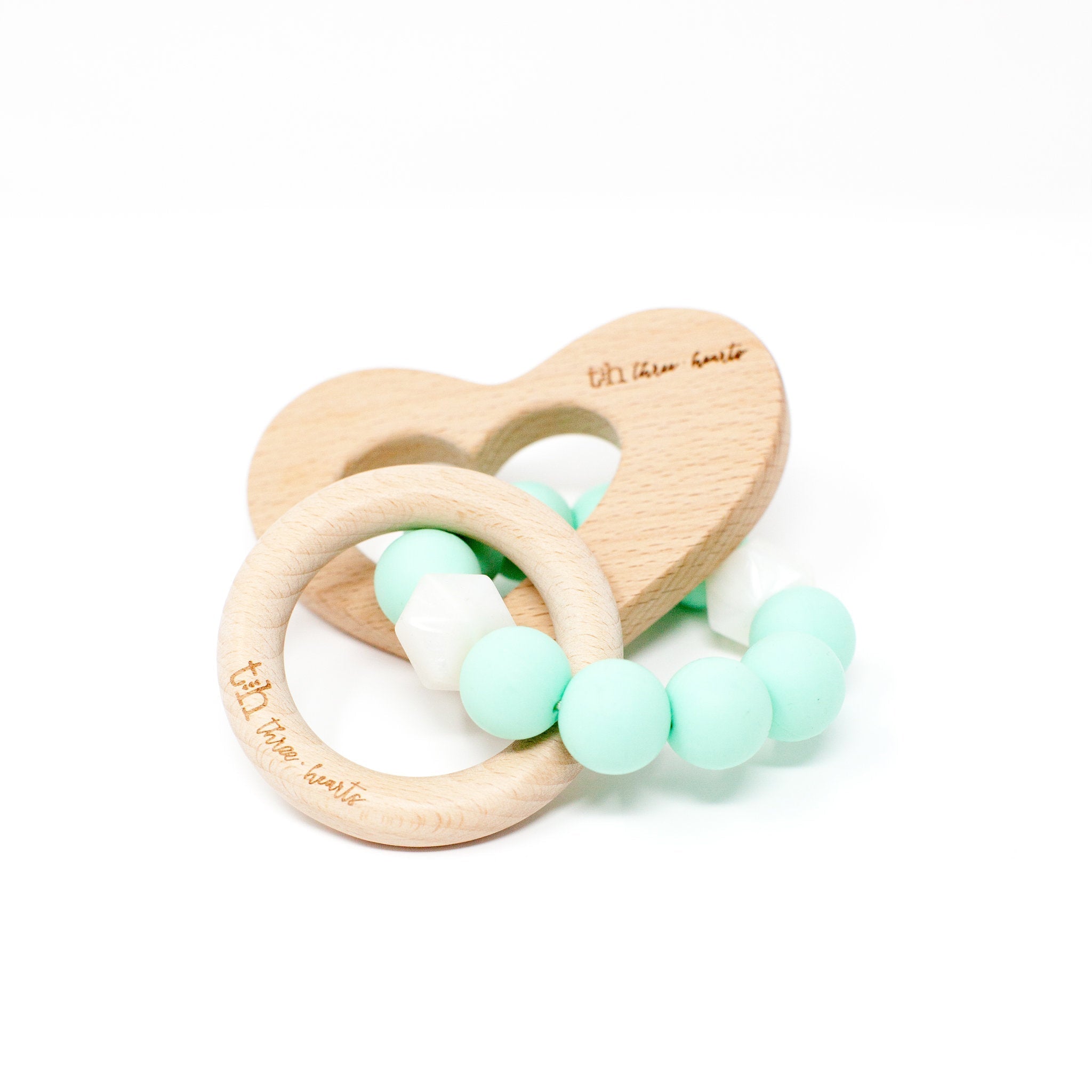 Wooden heart-shaped teether with mint green beads on a white background