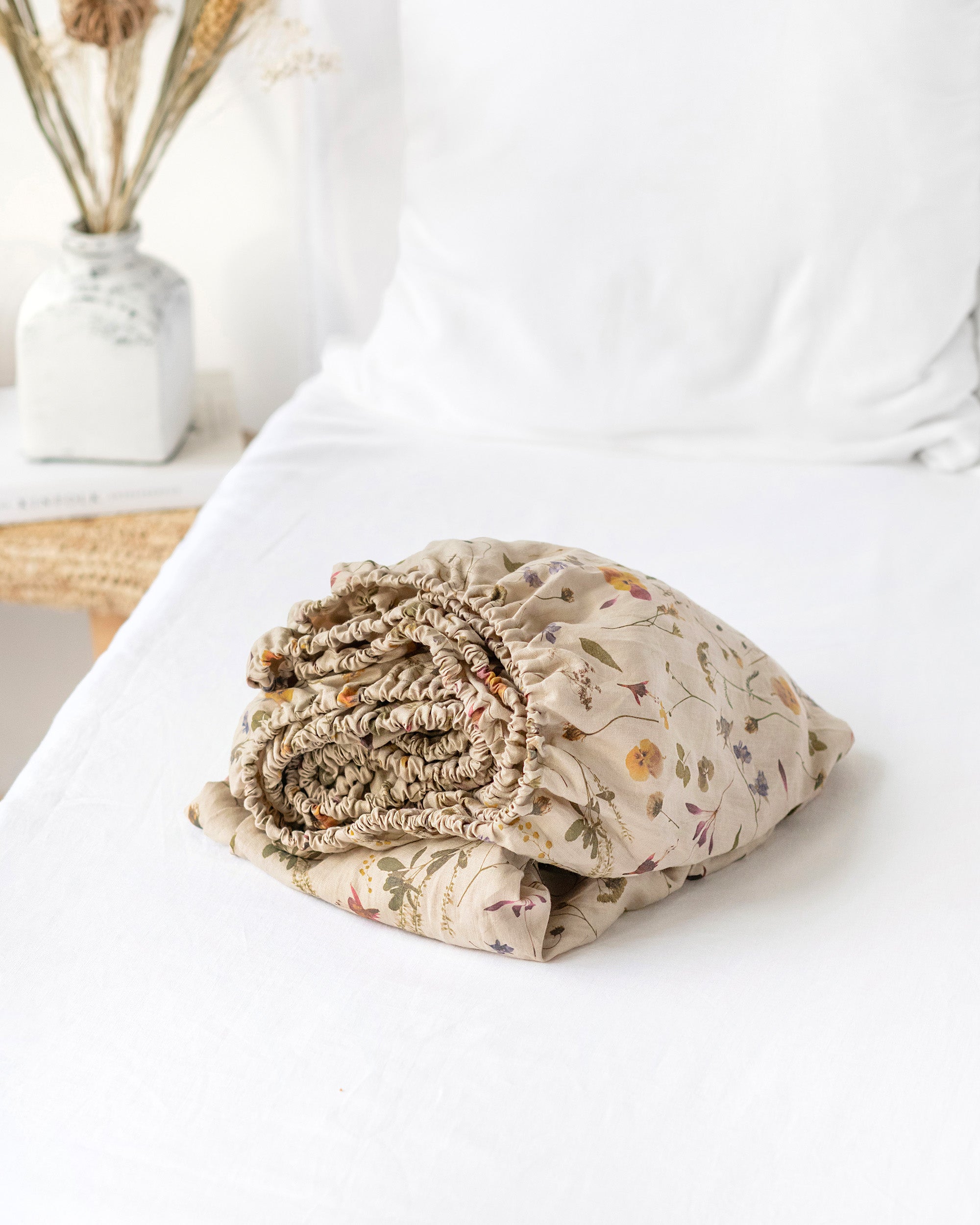 Folded floral blanket on a white surface with a blurred background
