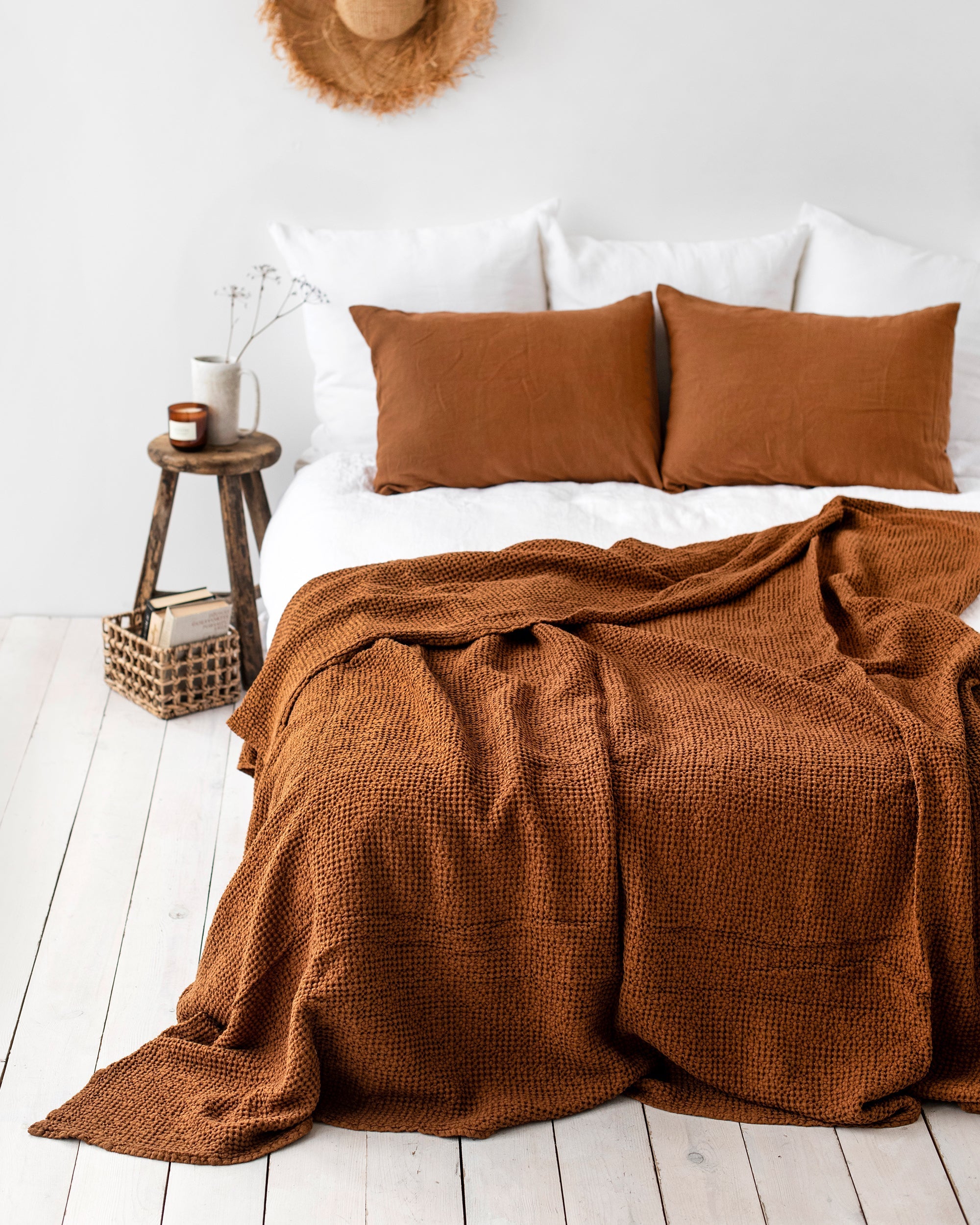 Bed with brown bedding and pillows in a bedroom setting.