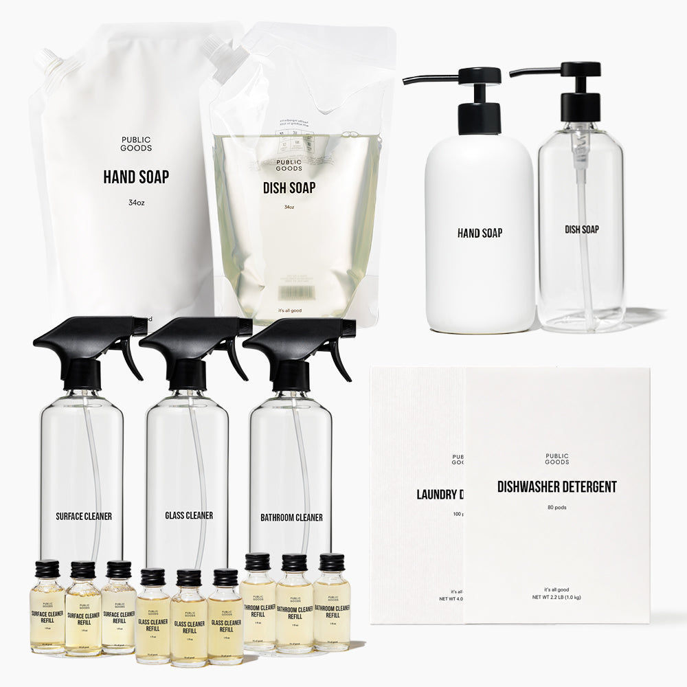 A set of Public Goods brand self-cleaning cleaning products, including hand soap, dish soap, surface cleaner, glass cleaner, bathroom cleaner, laundry detergent, dishwasher detergent, and refill pouches, arranged on a clean white background.