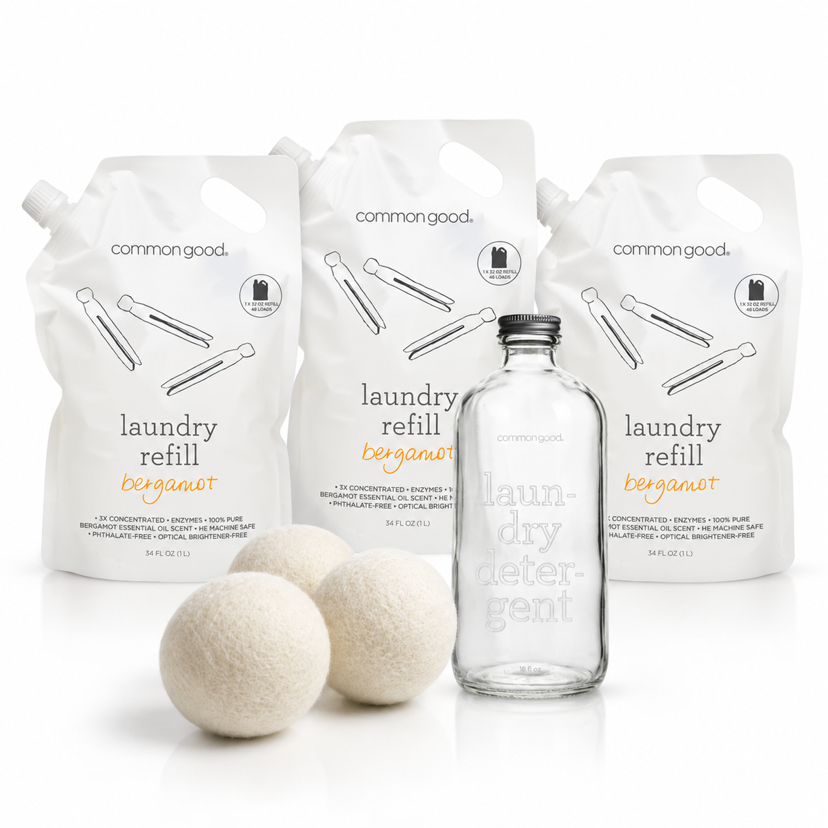 Common Good Laundry Starter & Stock-Up Bundle with three detergent refill pouches, one empty glass bottle, and three wool dryer balls