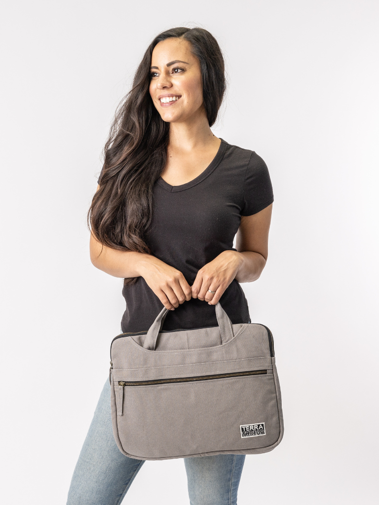Woman holding a gray bag with a visible brand logo on a white background