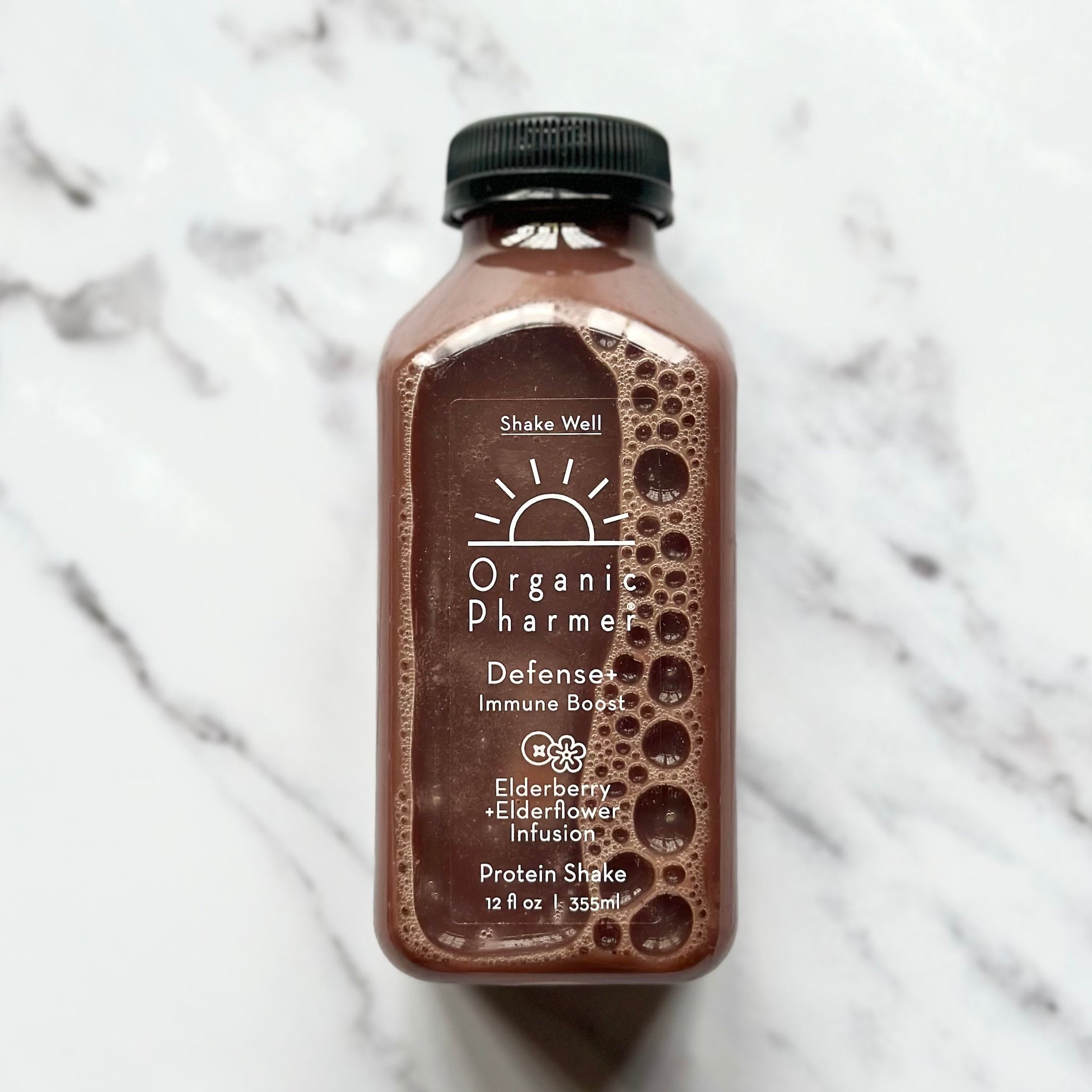 Bottle of Organic Pharmer protein shake on a marble surface