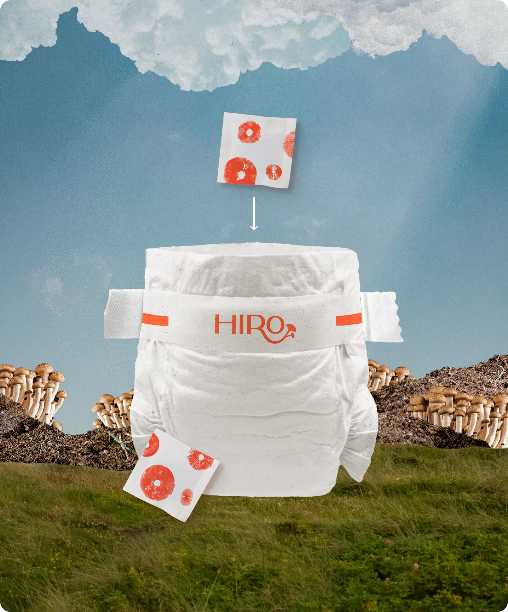 Hiro diaper with packaging on a grassy field with mushrooms and a blue sky.