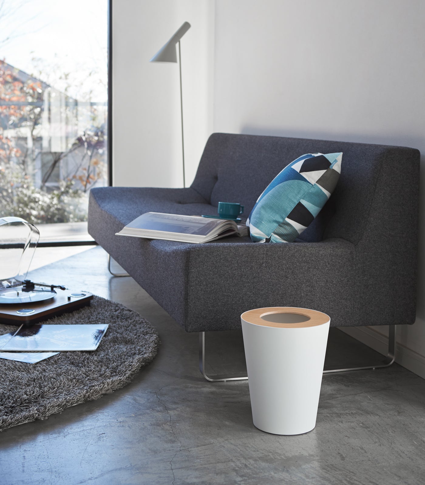 Modern living room with a gray sofa, white coffee table, and decorative pillow.
