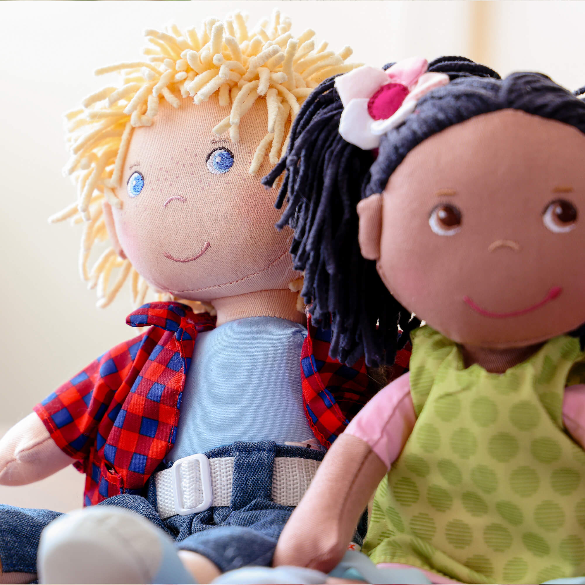 Two dolls with different hair colors and clothing sitting together.