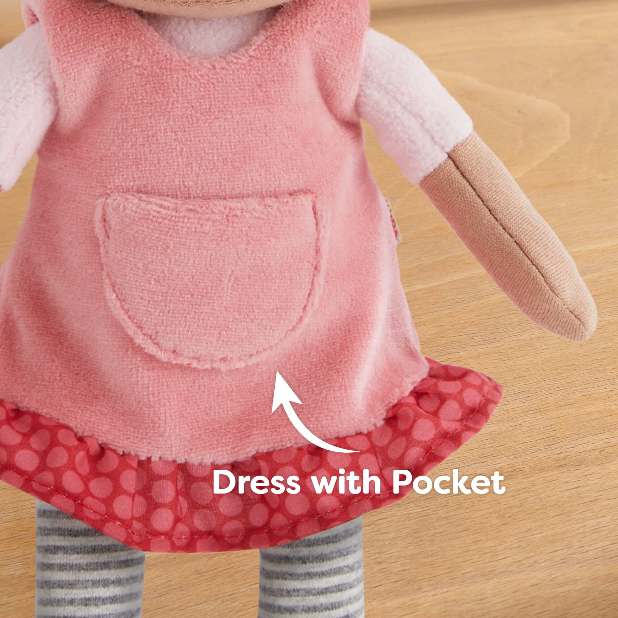 Toy dress with a pocket on a wooden surface