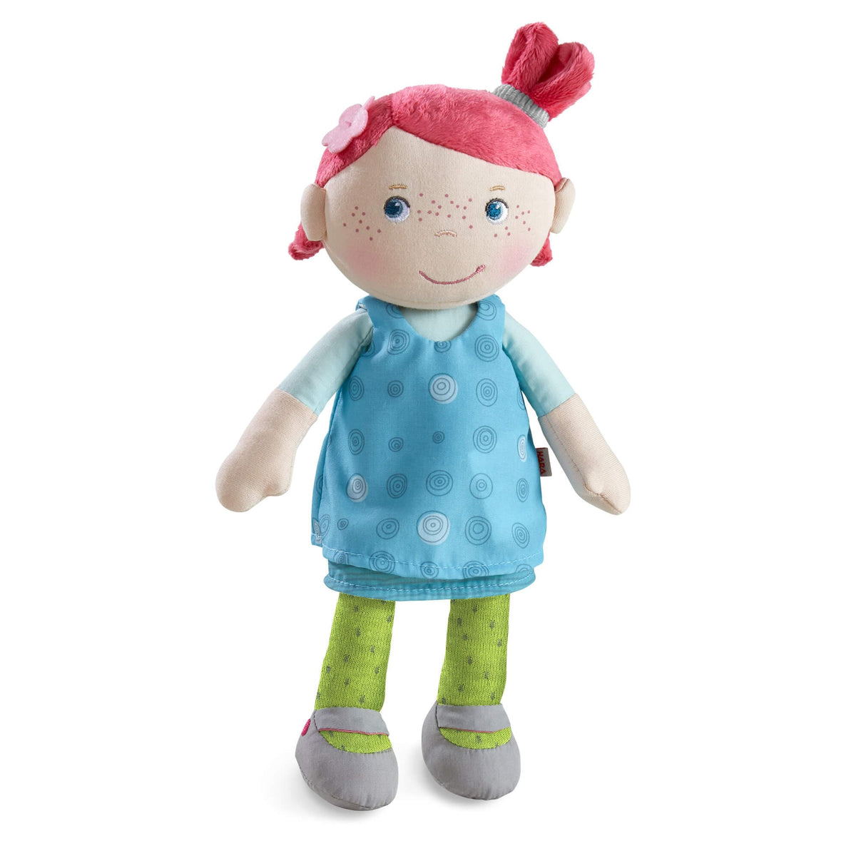 Plush toy with pink hair, blue dress, and green pants on a white background