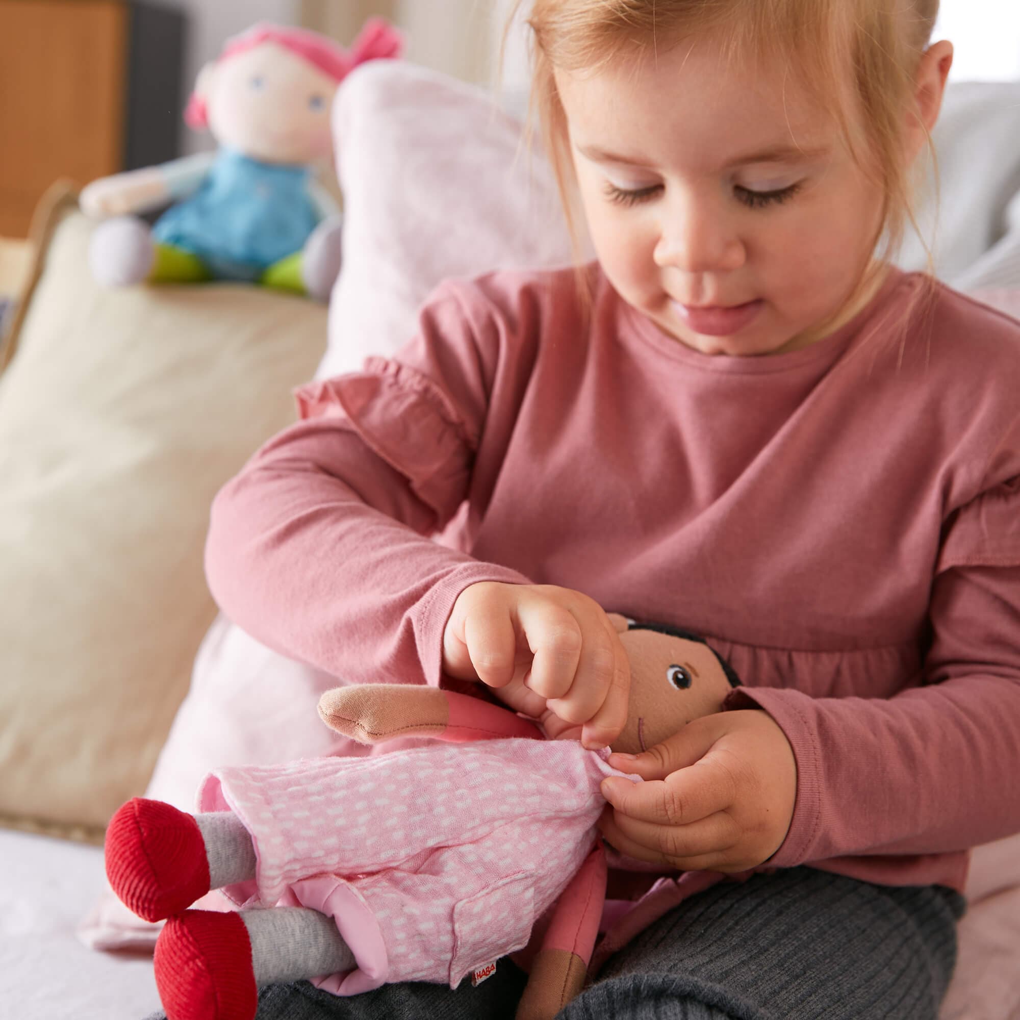 Child playing with a doll in a cozy indoor setting