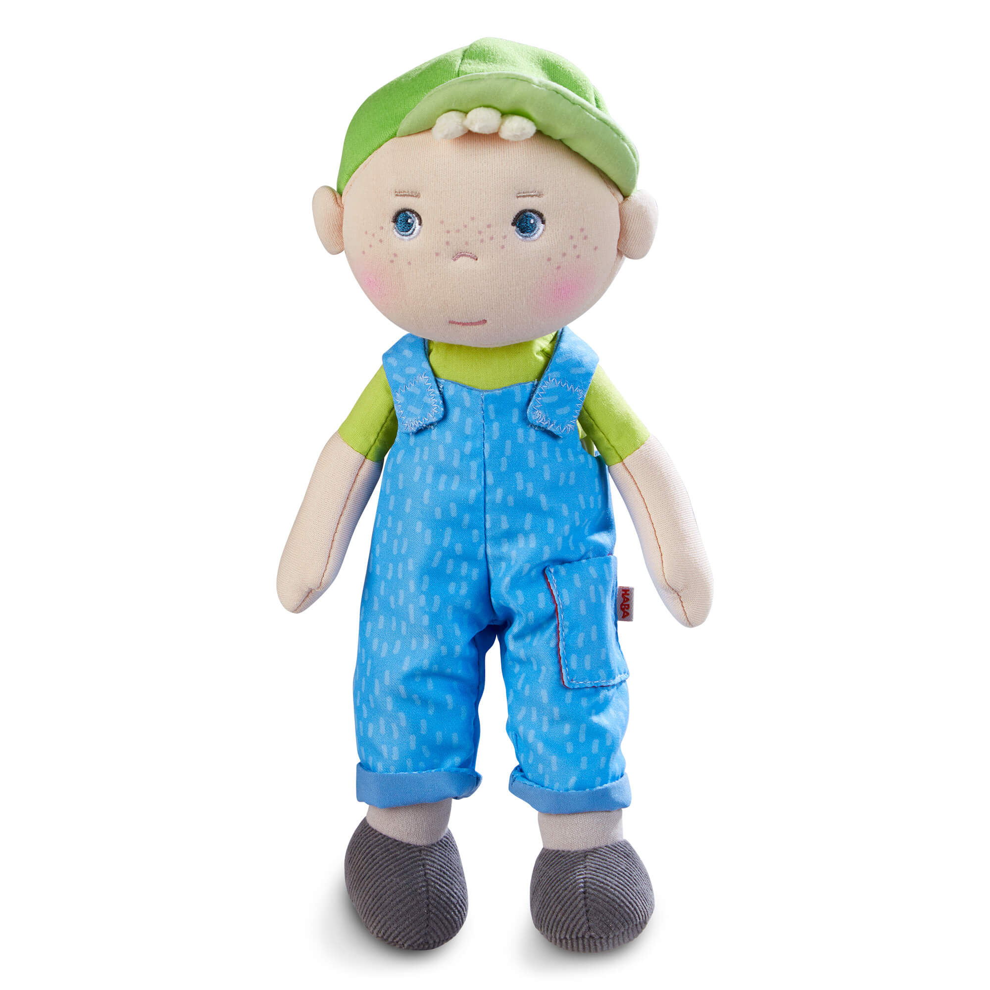 Stuffed toy doll with a green hat and blue overalls on a white background