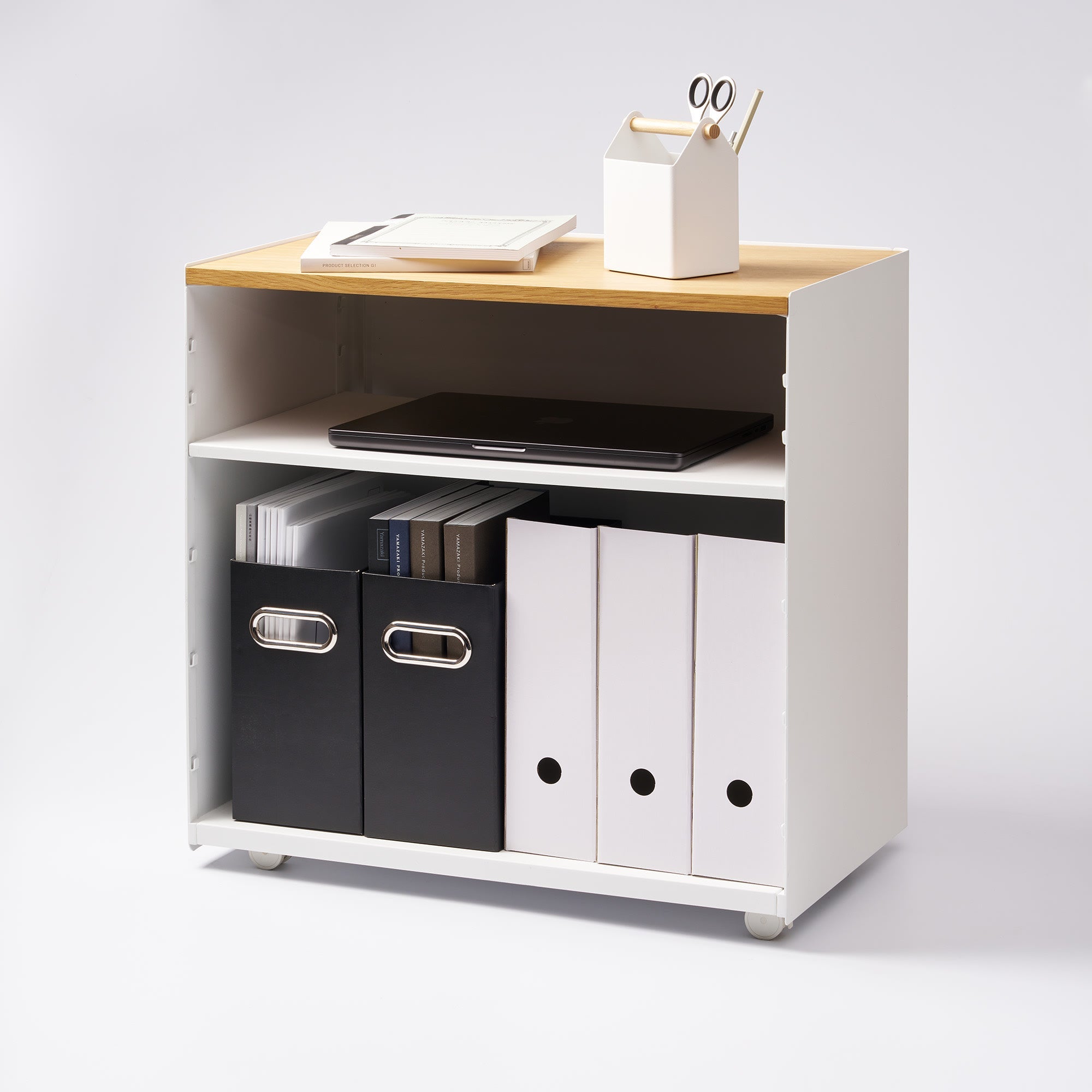 Small white desk with a wooden top, containing office supplies on a light gray background