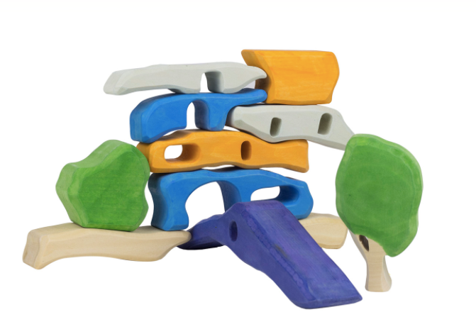 Colorful toy structure with various shapes and a slide on a white background