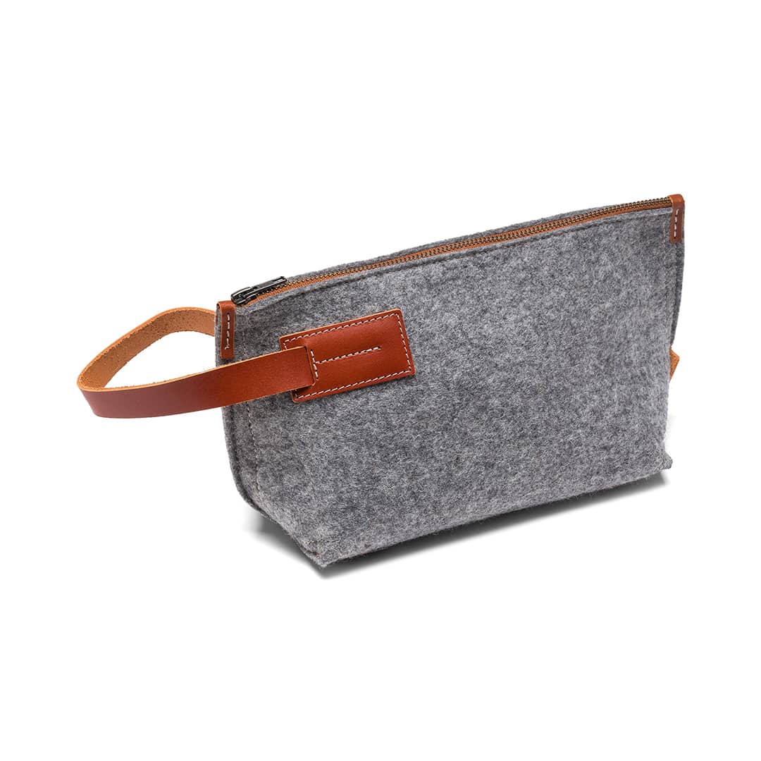 Gray pouch with brown handle and trim on a white background