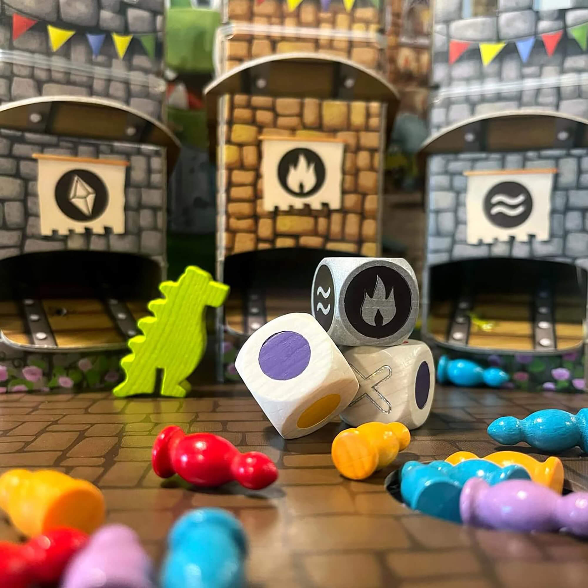 Colorful dice and game pieces on a table with miniature buildings in the background