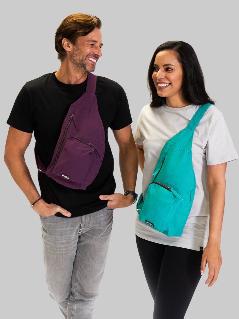 Two people wearing sling bags on a gray background