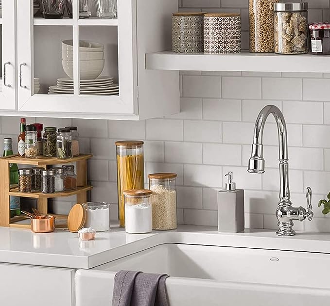 Modern kitchen with white cabinets, sink, and tiled backsplash.