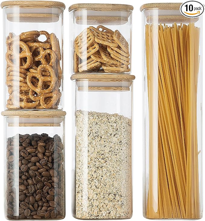 Set of five glass storage jars with bamboo lids containing various food items.