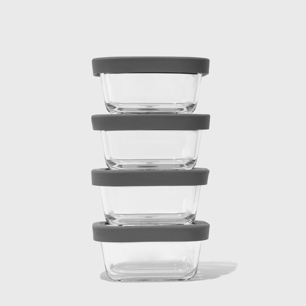Stack of glass food containers with gray lids on a white background