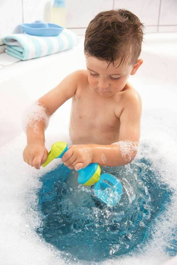 Child playing with bath toys in a bathtub filled with water and bubbles.
