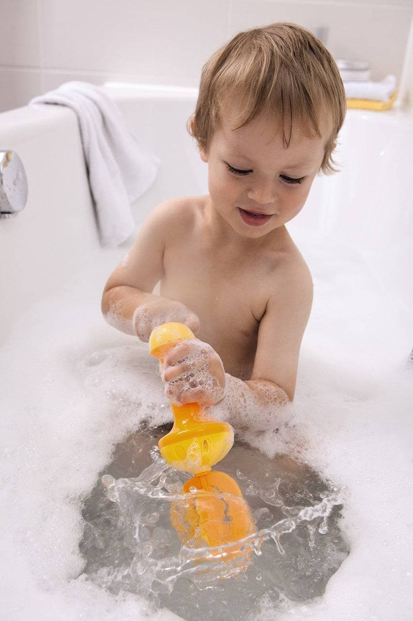 Child playing with toys in a bathtub filled with bubbles