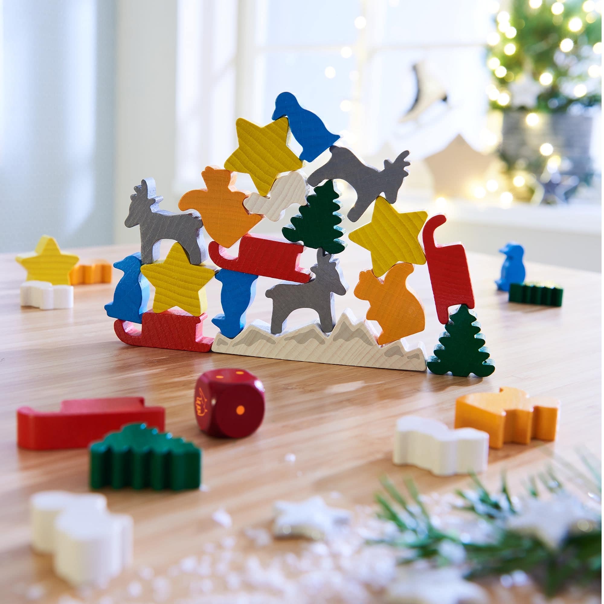 Colorful wooden advent calendar with Christmas-themed figures on a wooden surface.