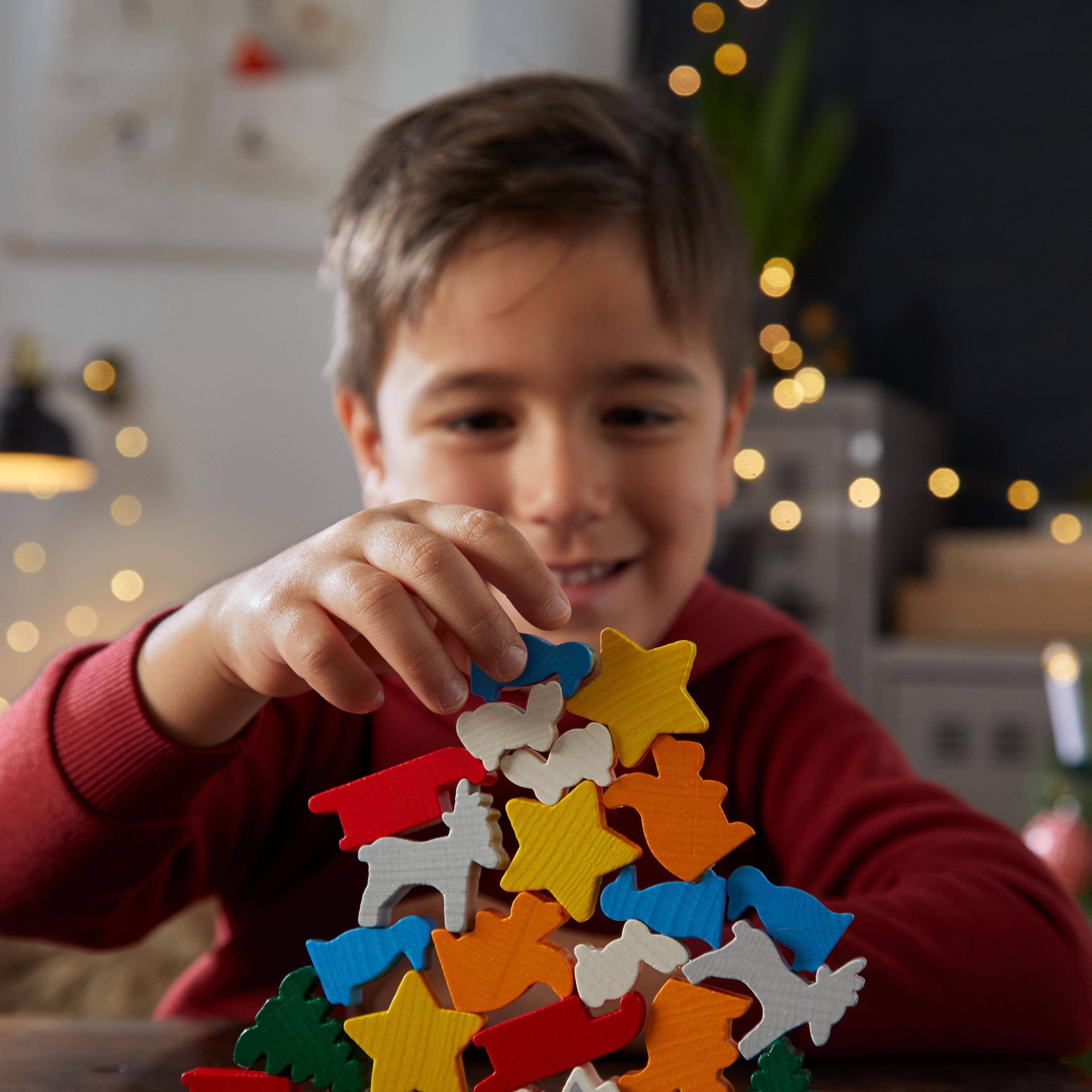 Child playing with colorful wooden shapes in a cozy indoor setting
