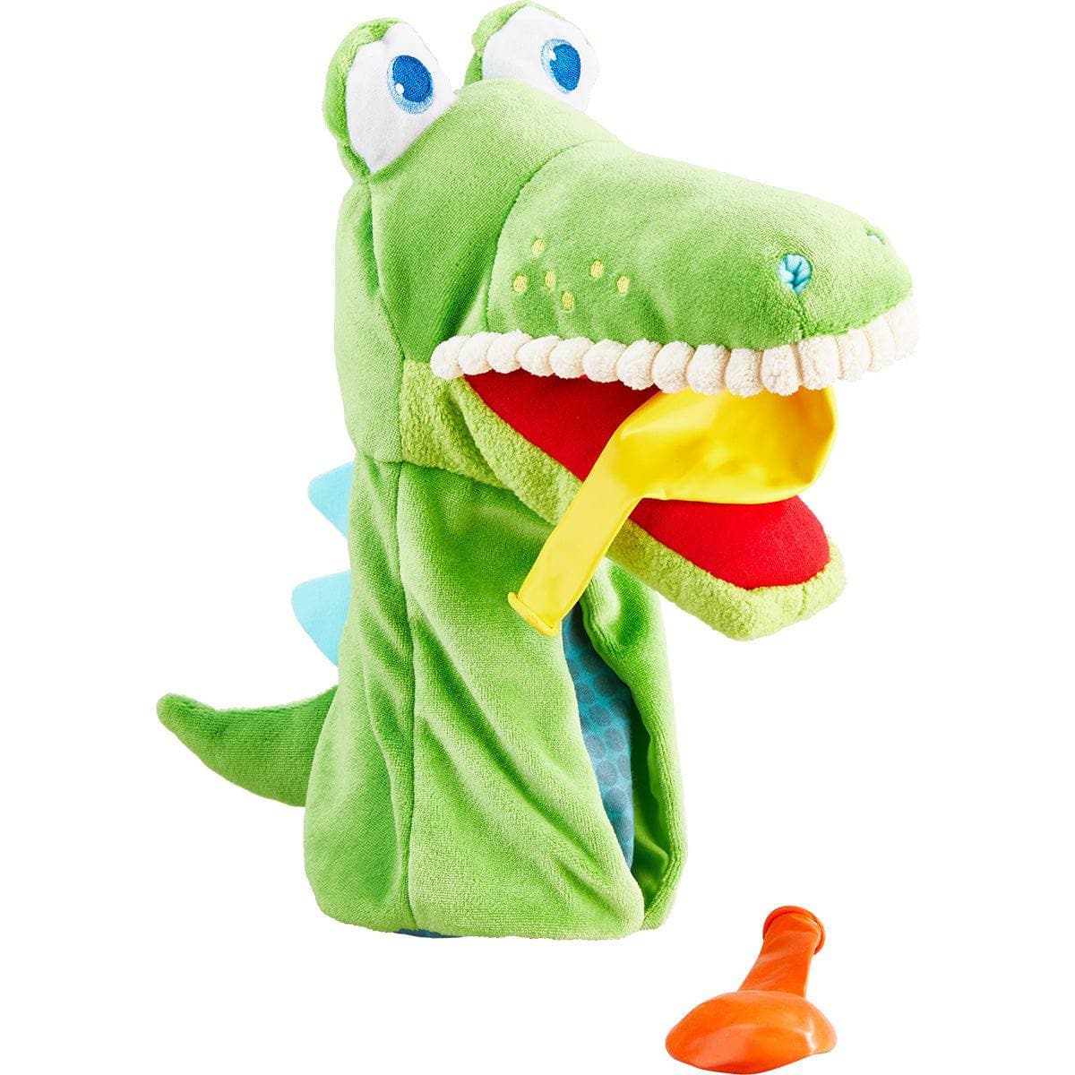 Green dinosaur-shaped plush toy with a red tongue on a white background