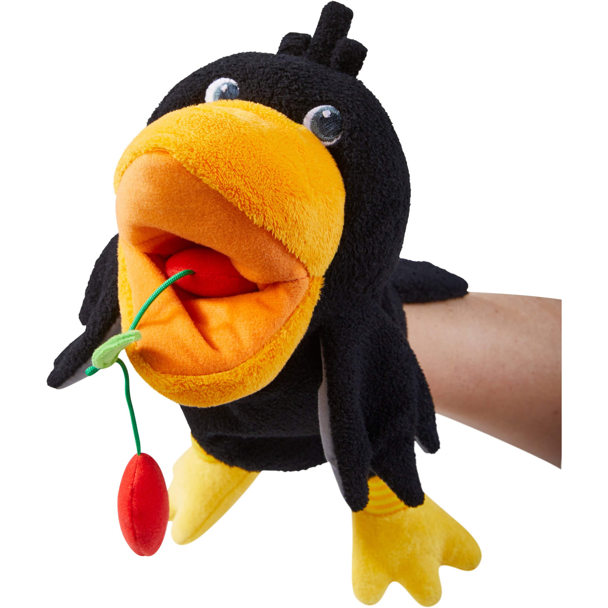 Plush penguin toy with a yellow beak and feet, held by a hand on a white background
