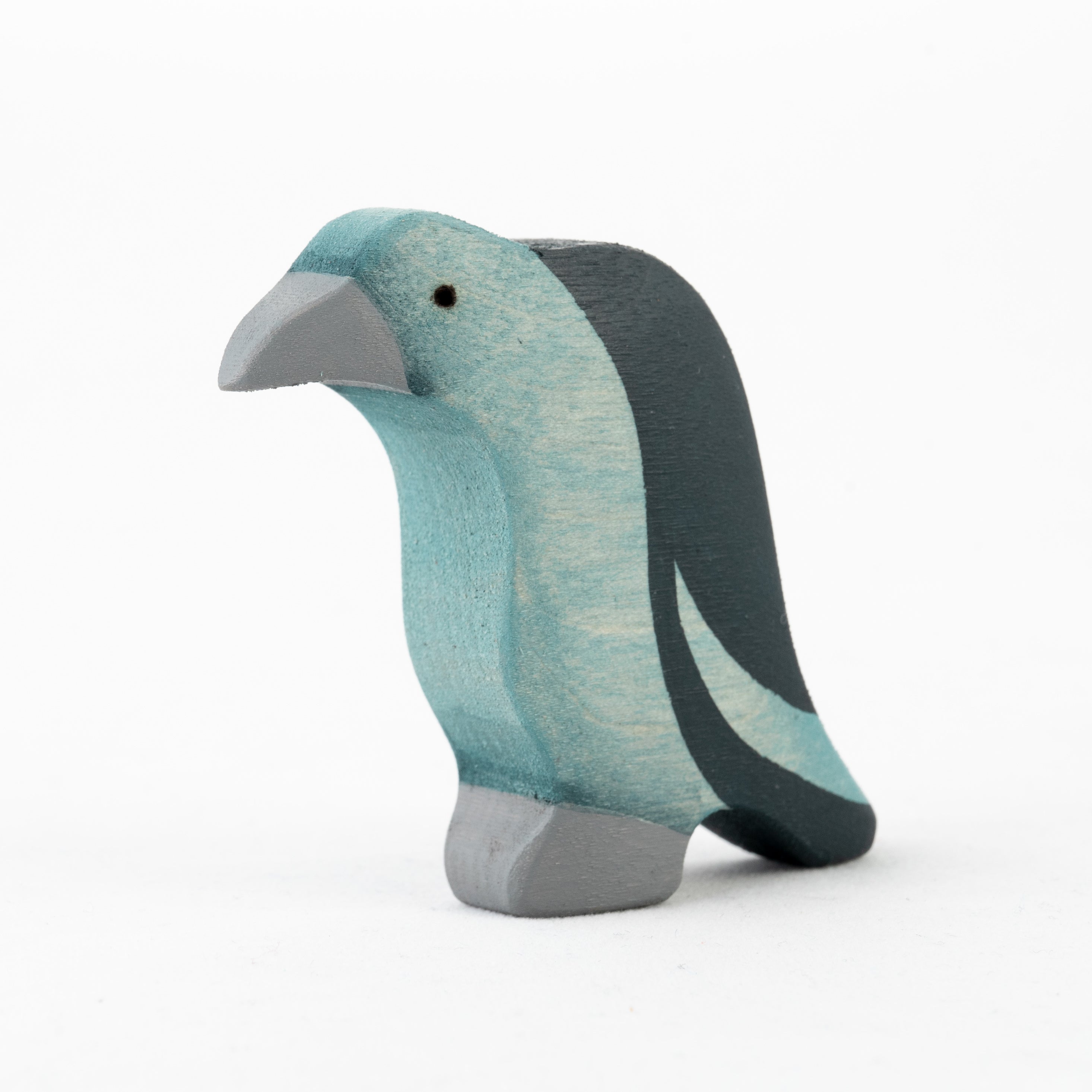 Wooden penguin toy with a gradient of blue and gray on a white background