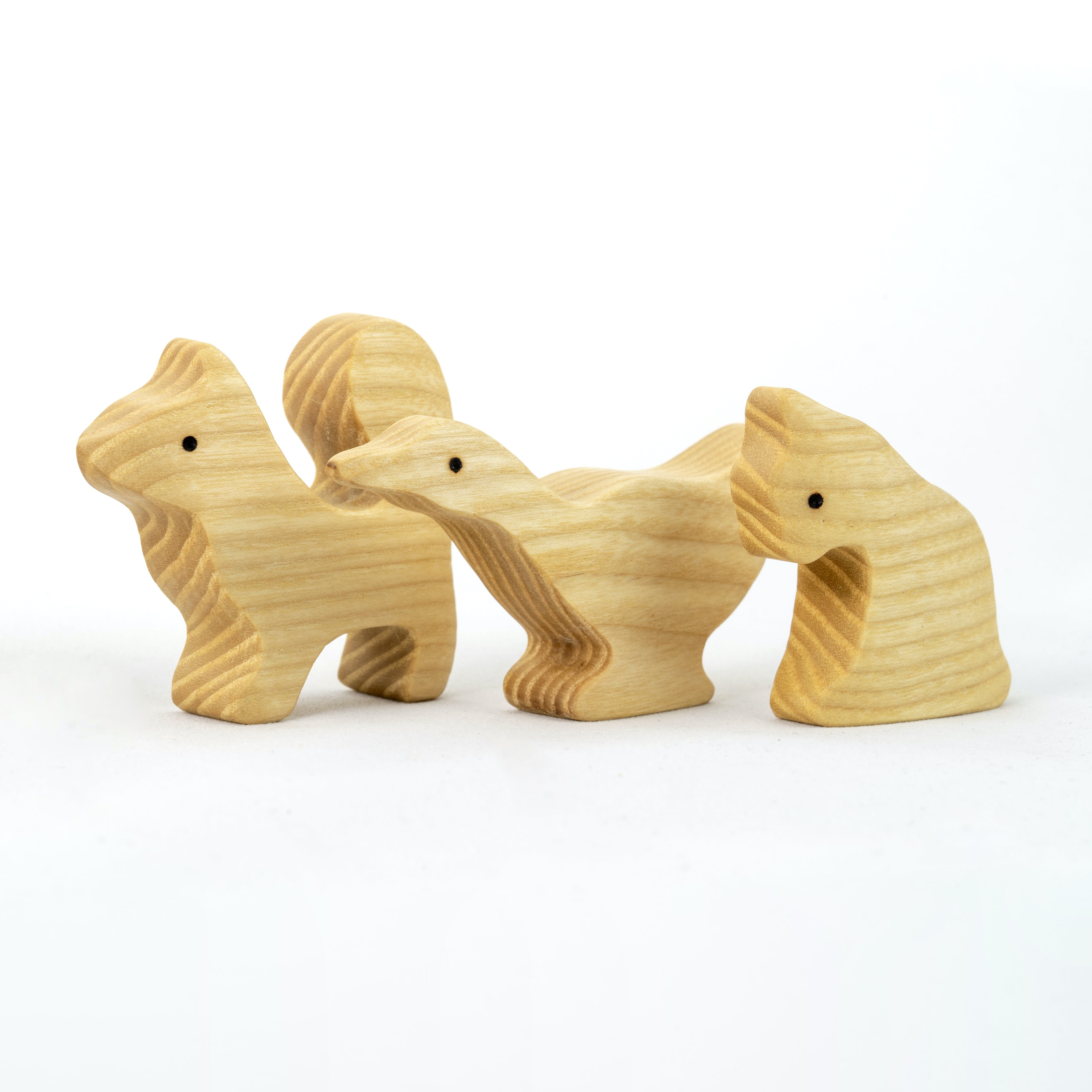 Set of four wooden animal figurines on a white background