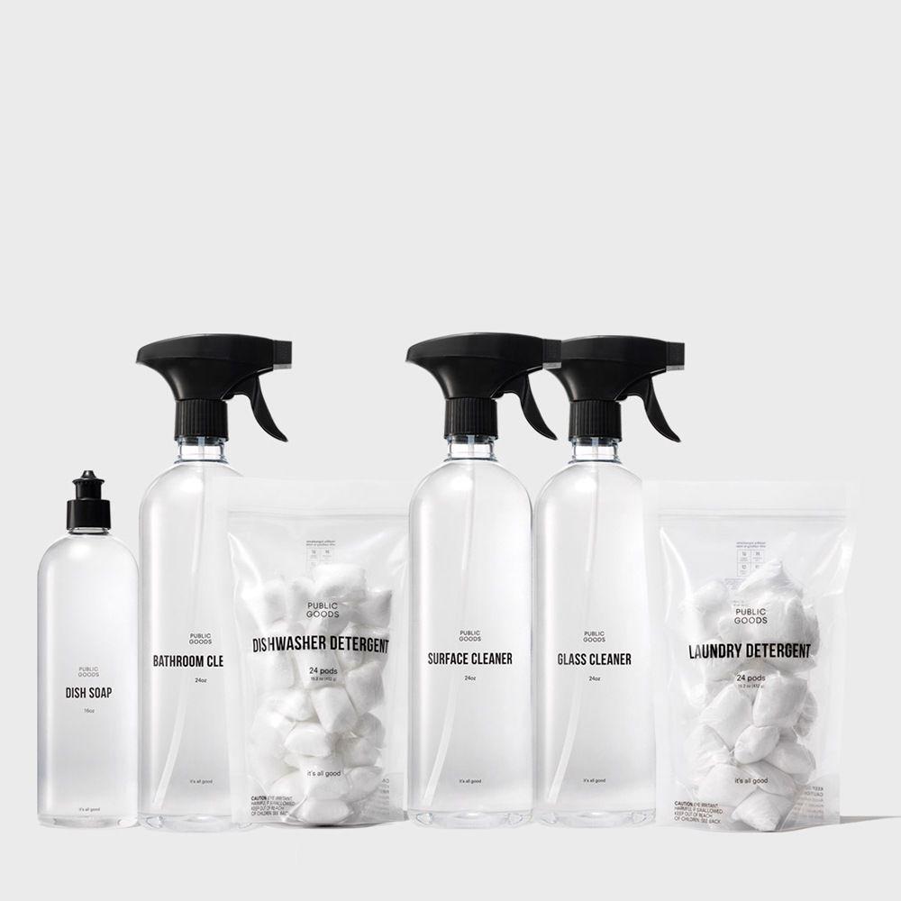 Set of cleaning products including bottles and a bag on a white background