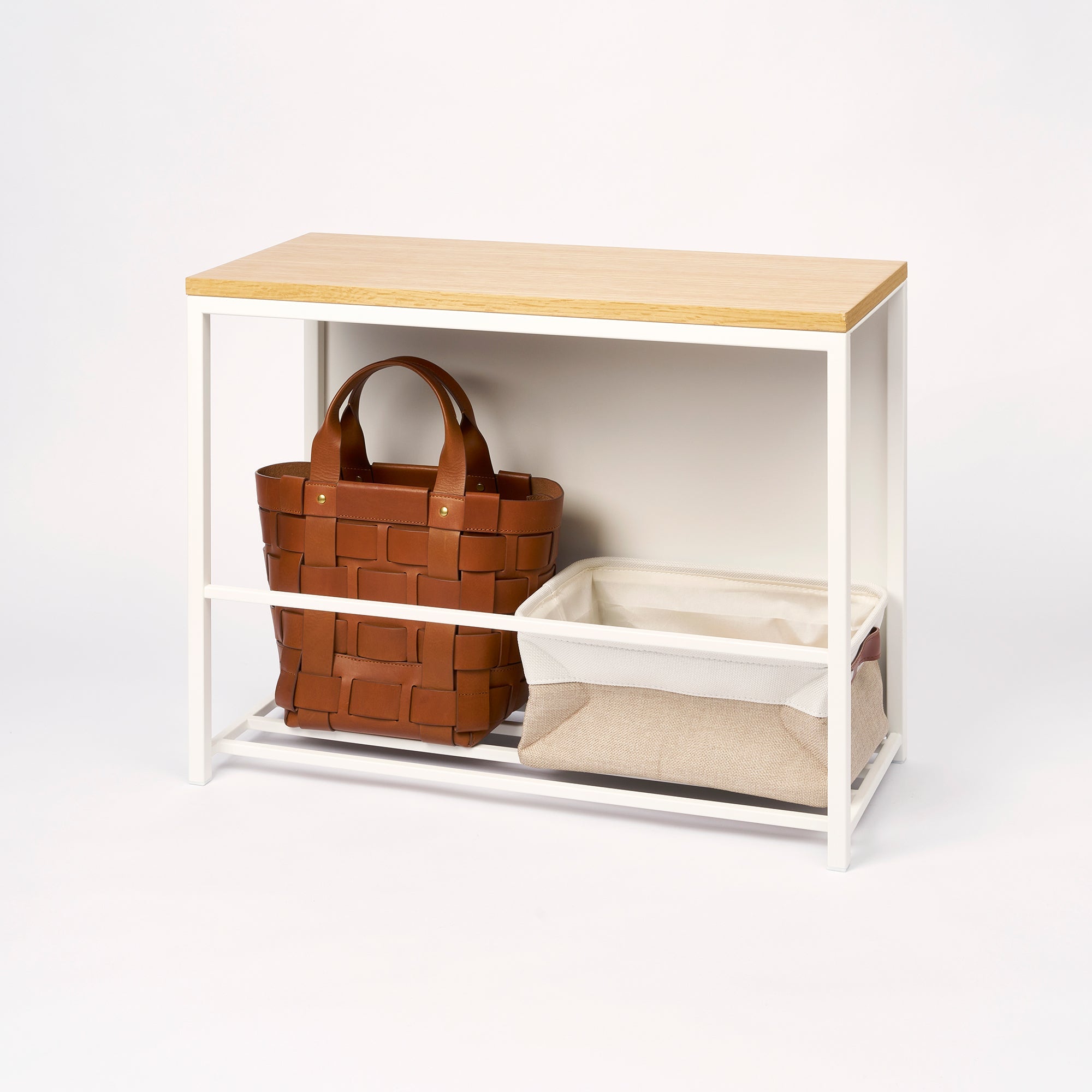 Small wooden table with storage baskets on a white background