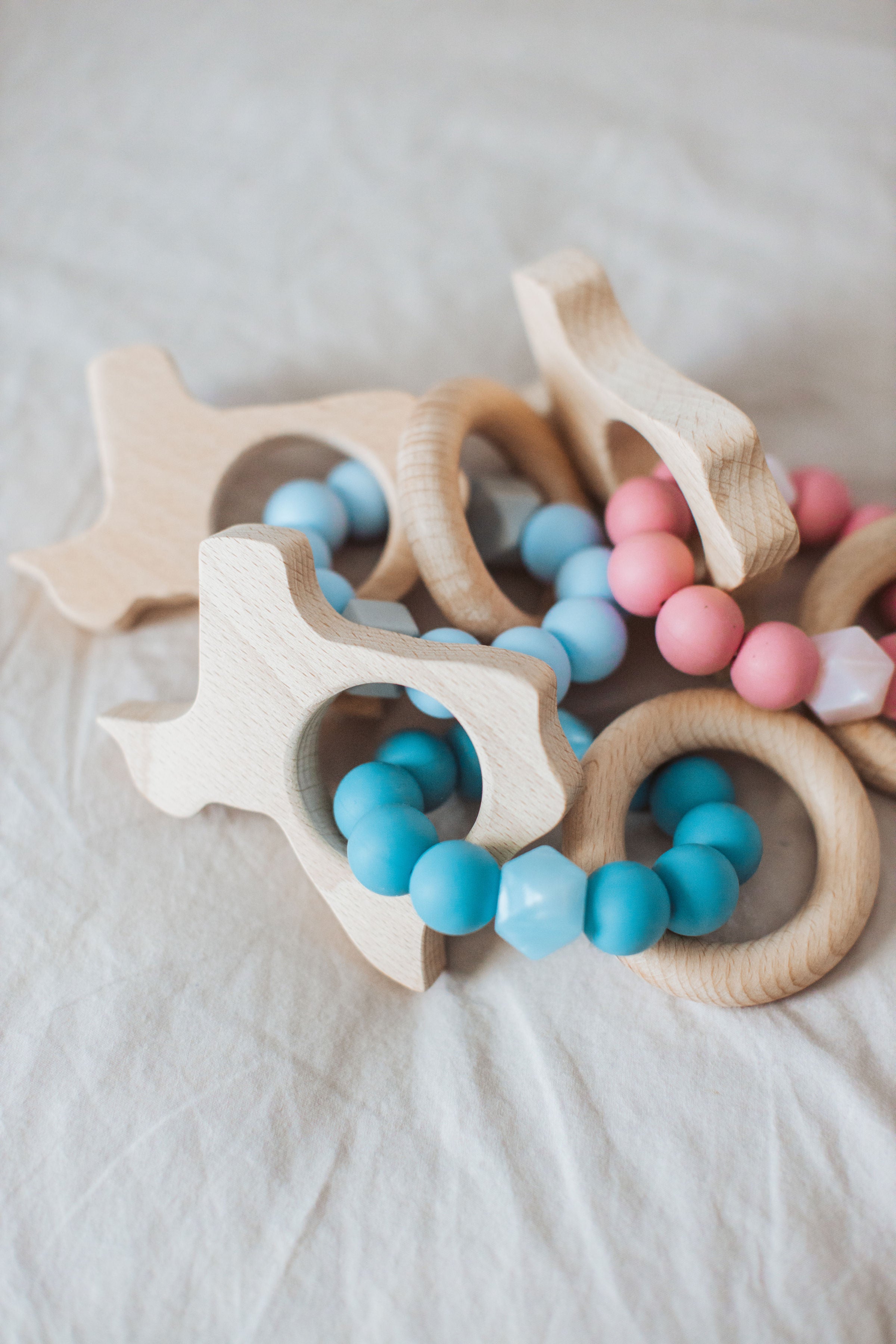 Wooden teething ring with colorful beads on a soft surface
