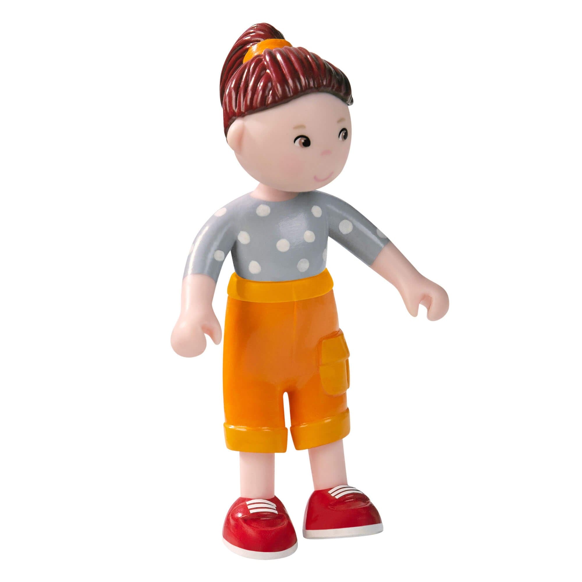 Toy figure of a child wearing a gray shirt with white polka dots, orange shorts, and red shoes on a white background.