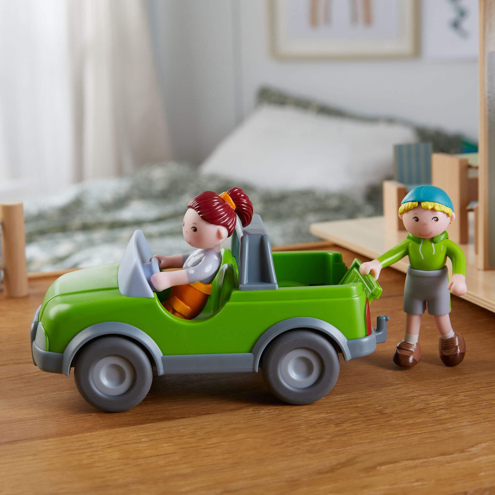 Toy green car with figures on a wooden surface